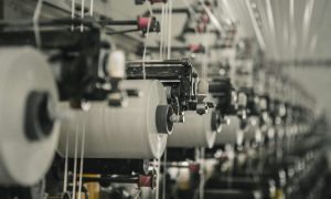 Hilos colocados sobre maquinas industriales de vestuario y textil