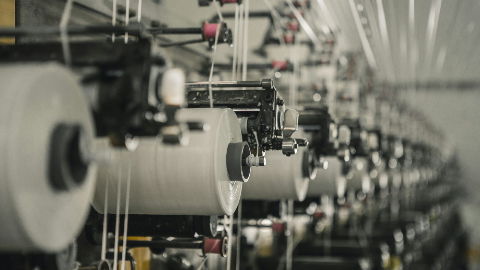 Hilos colocados sobre maquinas industriales de vestuario y textil